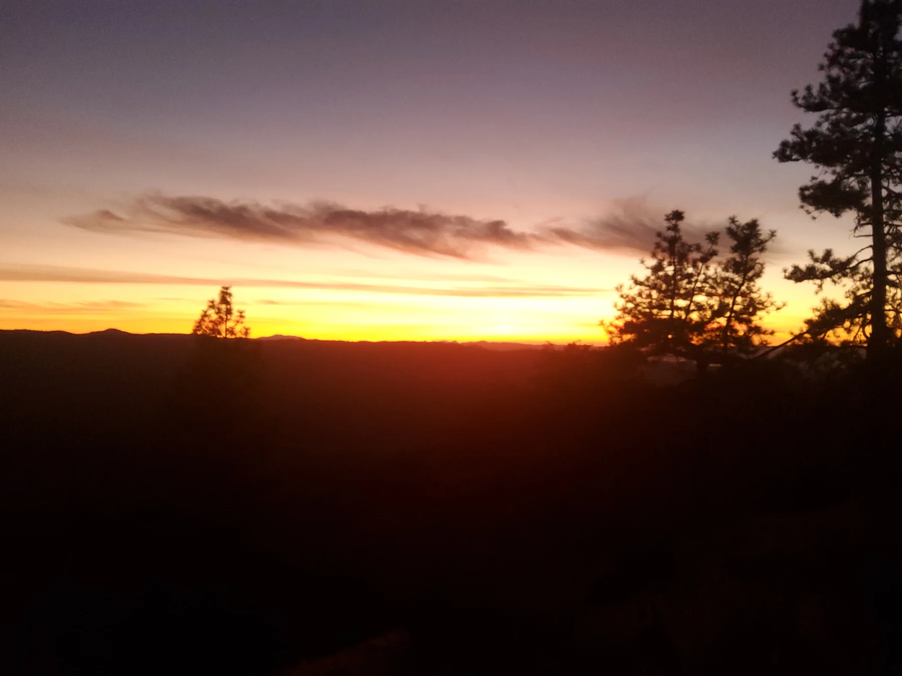 Bright orange sunset along the distant ridge near Rogue Rapid Farms