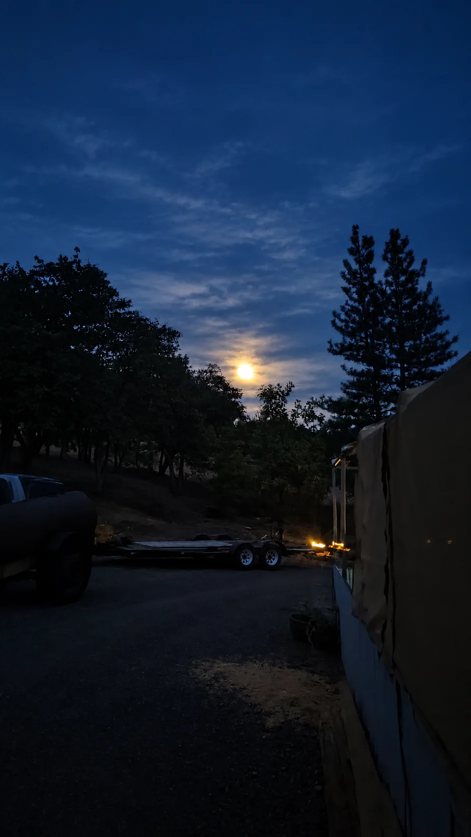 Moon glowing over the farm beneath a deep blue night sky