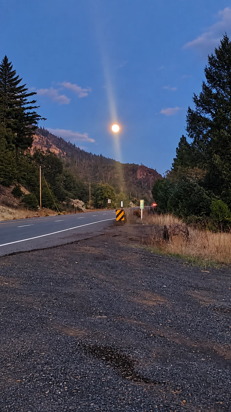 Moonrise above a Southern Oregon road at blue hour